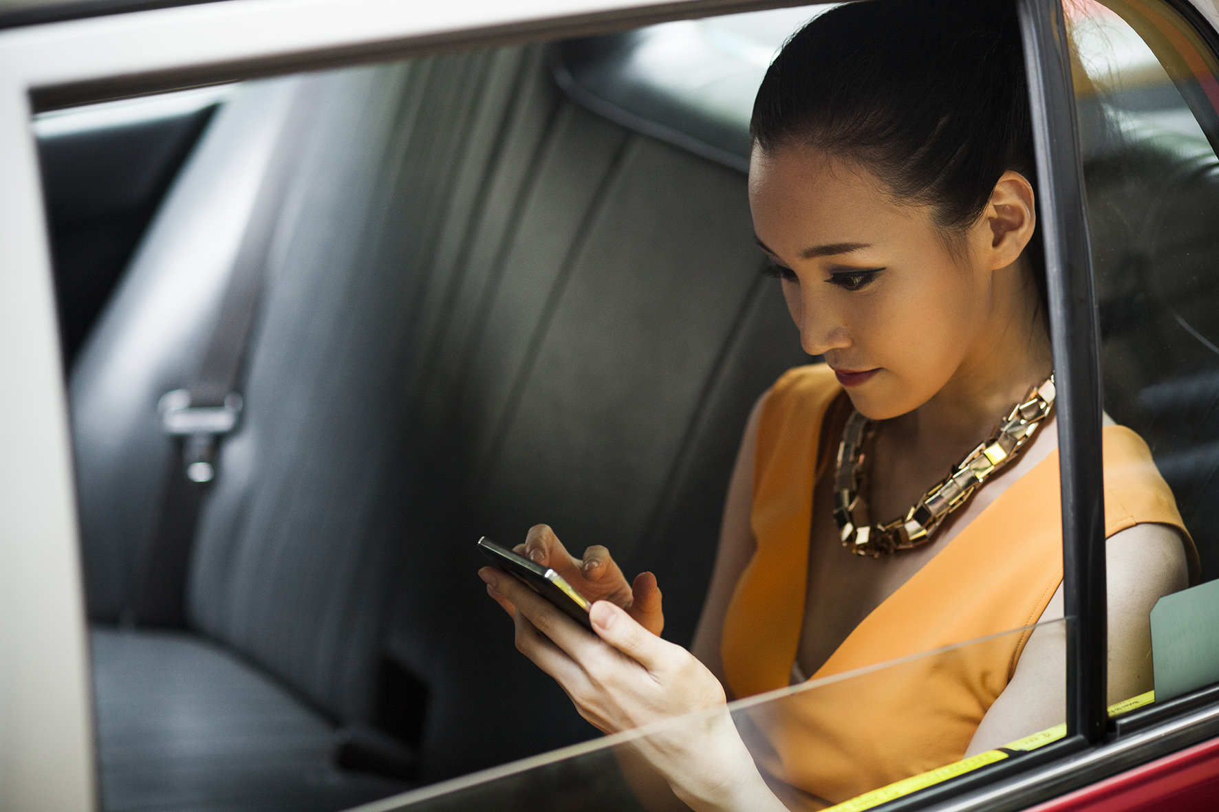 Woman in a car with a smartphone