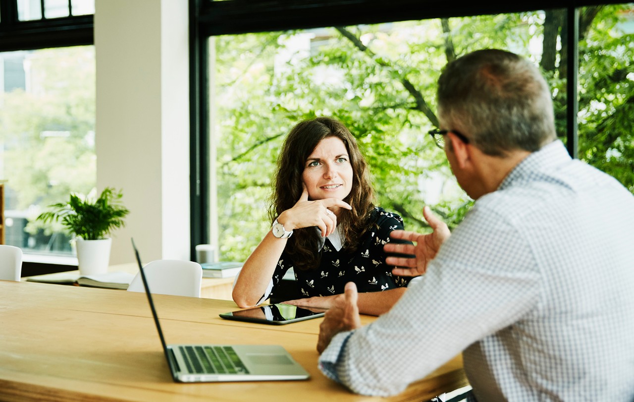 Business colleagues having planning meeting in small office conference room